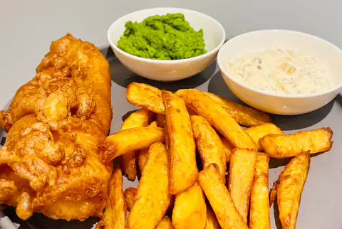 Battered fish and thick-cut chips served with mushy peas and tartare sauce
