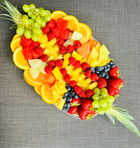 A fruit platter fanned with orange slices, strawberries, melon and blueberries