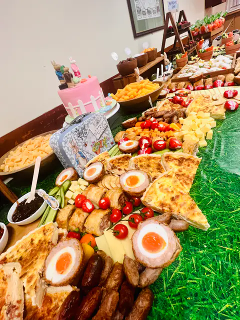 A garden party graze table with scotch eggs, cheese, chutney and fresh fruit