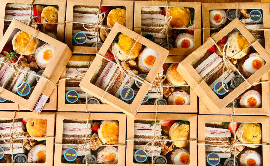 Westwoods grazeboxes tied with string, filled with sandwiches, scotch eggs and cake