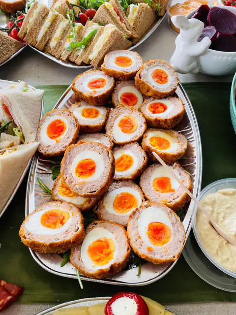A platter of halved scotch eggs with dipping sauce
