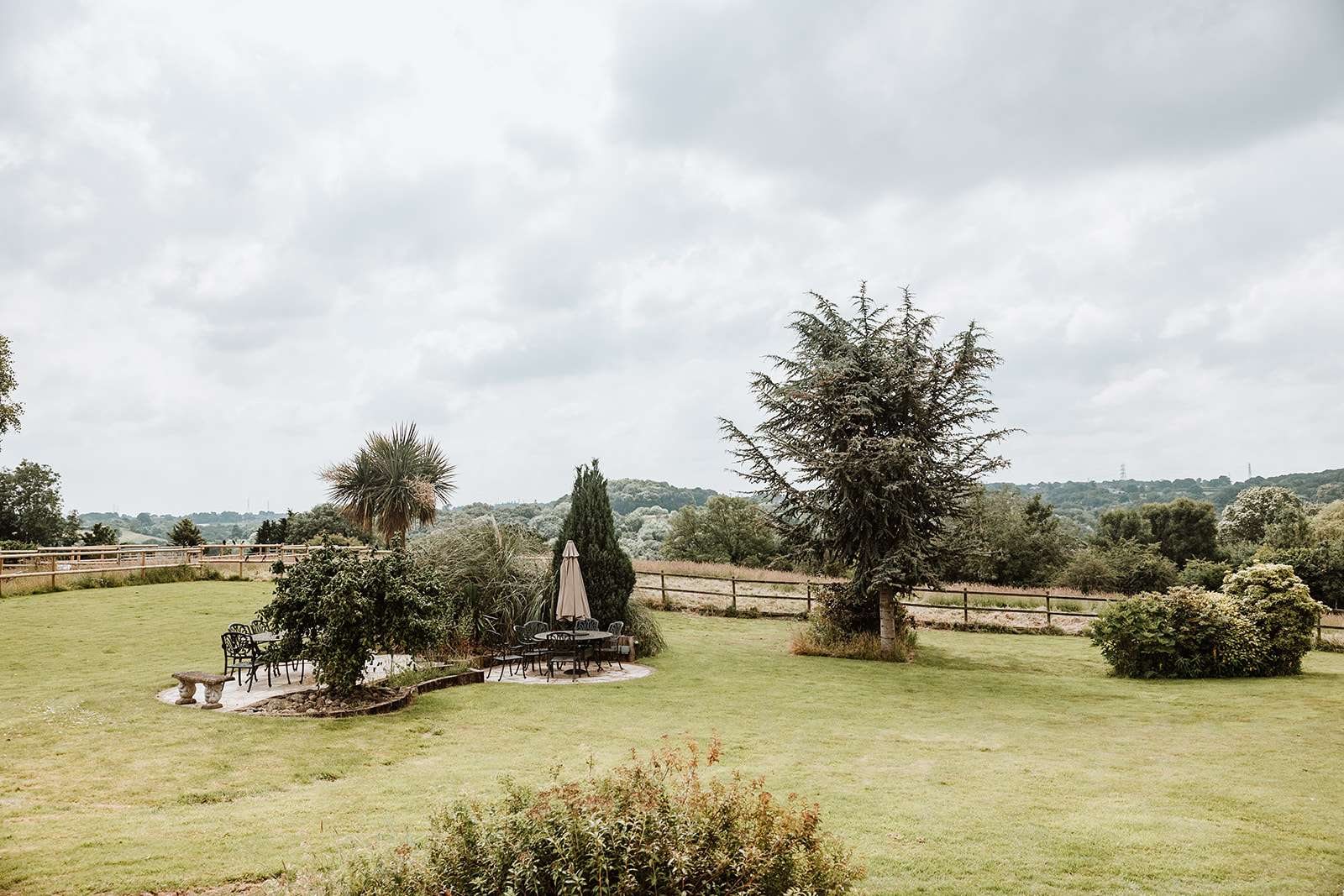 The sweeping lawn and garden seating at The Woodlands with countryside beyond